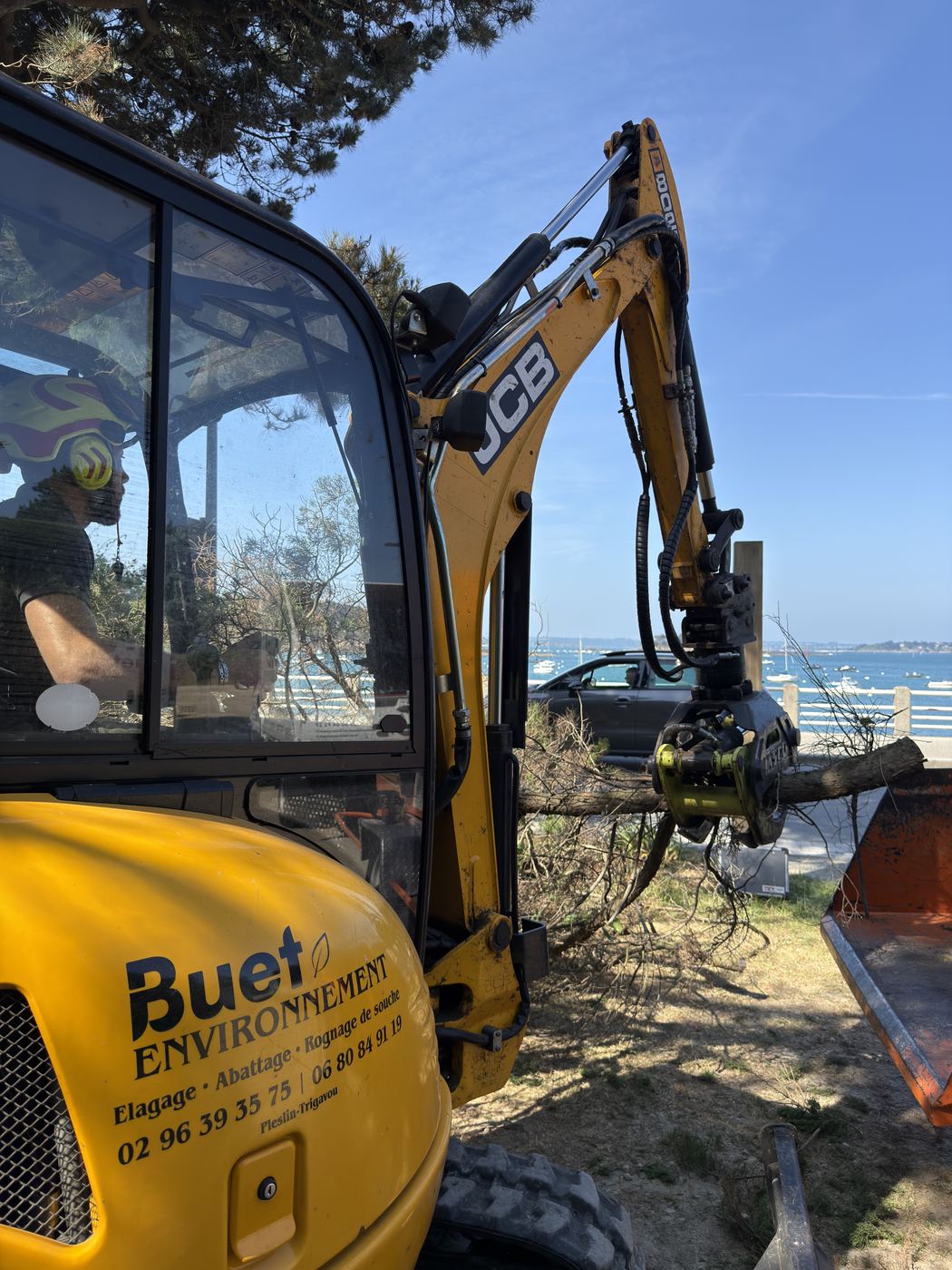 Mini-pelle à grappin Buet Environnement sur un chantier en bord de mer